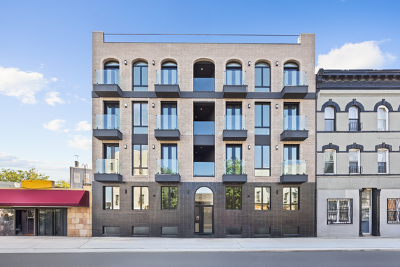 Front view of a multi-story residential building with balconies.