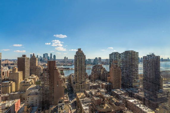 Panoramic view of cityscape with tall buildings and river.