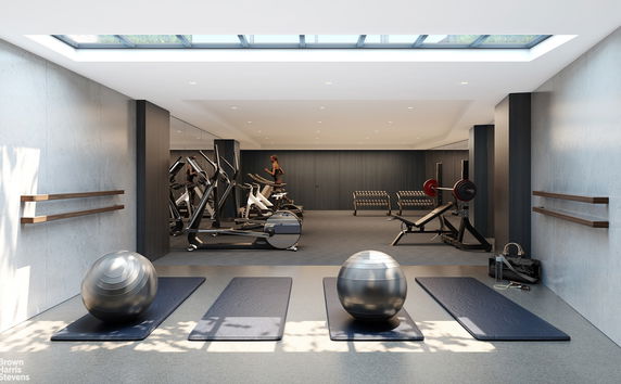 Interior view of a modern gym with exercise equipment and skylight.