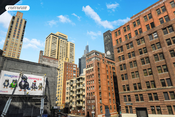 Cityscape view with multiple tall buildings and urban structures against a blue sky.