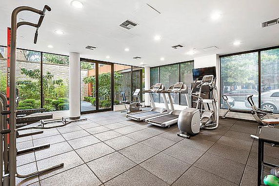 Interior view of a gym with treadmills and workout equipment.