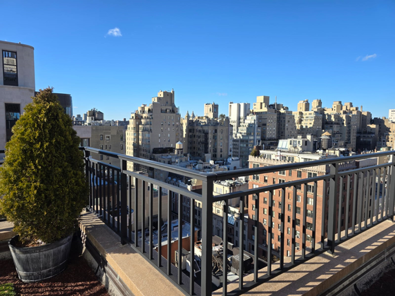 Panoramic view from a rooftop showing multiple buildings under a clear blue sky.