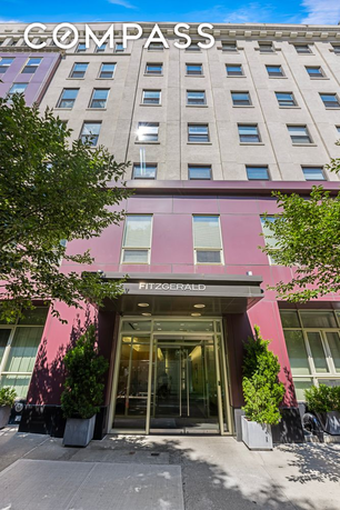 Front view of a mid-rise building with large entrance and multiple windows.