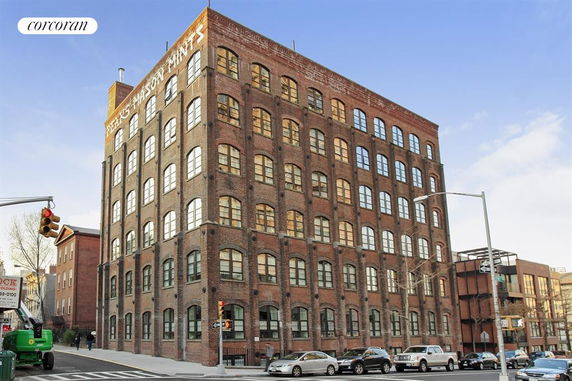 Front view of a multi-story brick building with large arched windows.