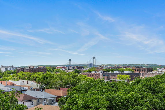 Panoramic view of a cityscape with a prominent bridge and residential buildings.