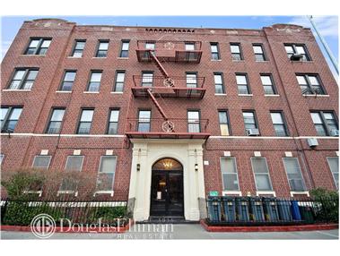 Front view of a multi-story brick building with a fire escape.