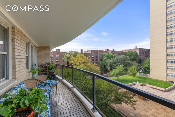 Balcony view of surrounding apartment buildings and trees.