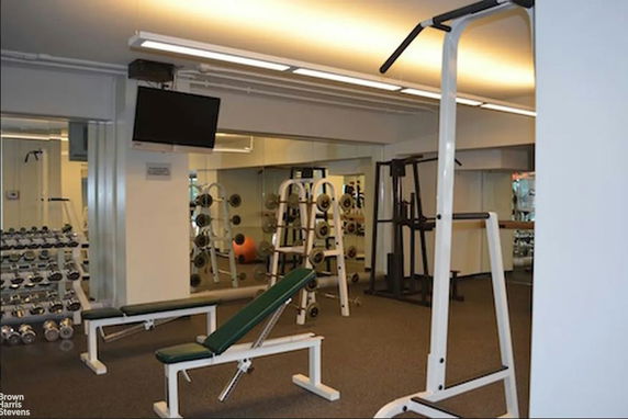 Interior view of a gym with workout equipment and weights.