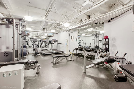 Indoor gym area with various fitness equipment including treadmills and weights.