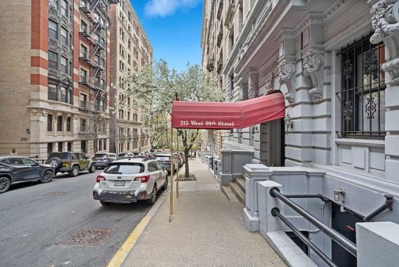 Front view of a residential building entrance with a red canopy labeled 315 West 99th Street.