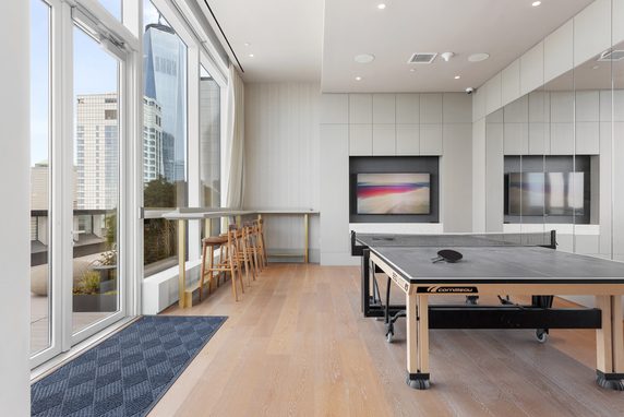 Room with a ping pong table and seating area.