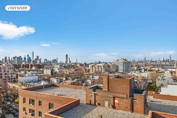 Panoramic view of a city's skyline with various buildings and a bright blue sky.