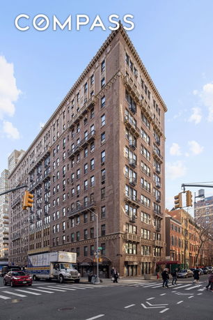 Front view of a multi-story brick building on a city street corner.