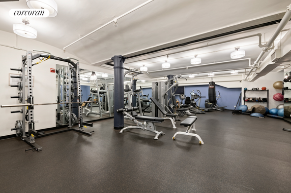 Interior view of a gym area with various exercise equipment and weights.