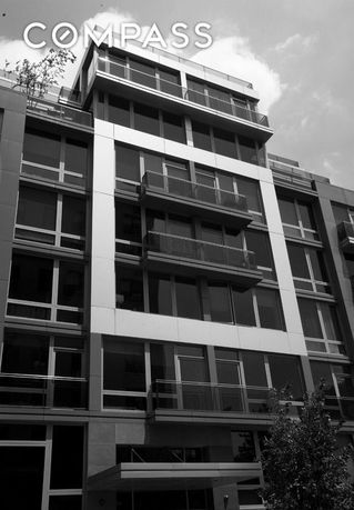 Front view of a multi-story building with large windows and balconies.