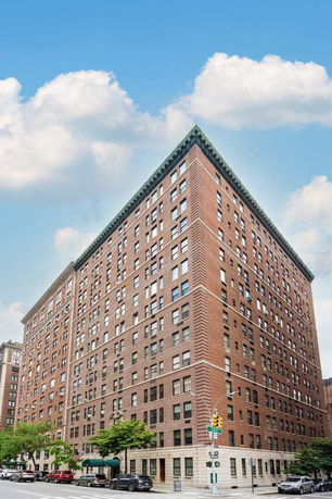 Corner view of a multi-story brick apartment building.