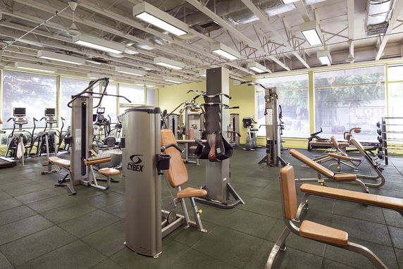 Interior view of a gym with various exercise machines and equipment.