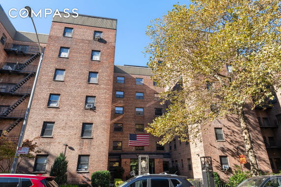 Front view of a multi-story brick building with an American flag displayed.