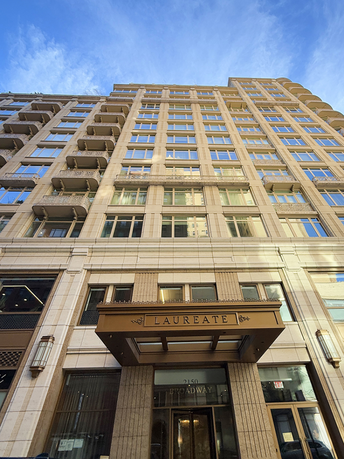 Front view of a multi-story building with large windows and balconies.