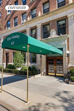 Front view of a multi-story brick building with an entrance canopy and decorative architectural details.