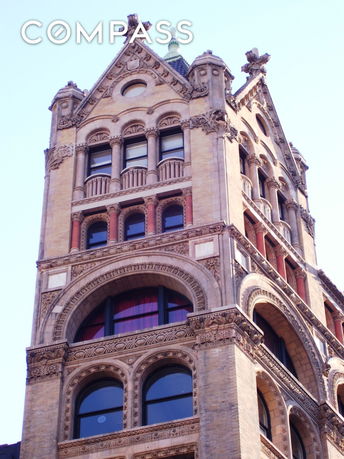 Front view of a multistory building with decorative arches and windows.
