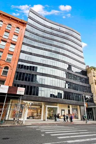 Front view of a multi-story modern building with a glass facade.