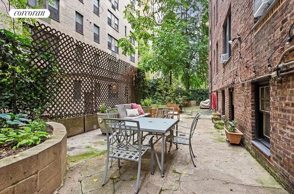 Outdoor area with patio furniture next to a brick building.