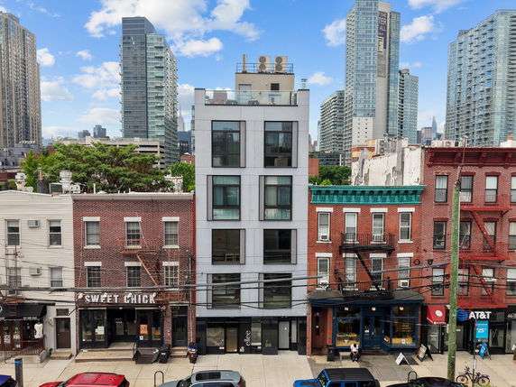 Front view of a row of commercial and residential buildings in an urban area.