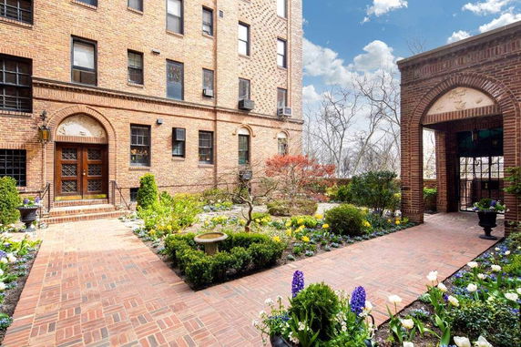 Front view of a brick residential building with arched doorway entrance.