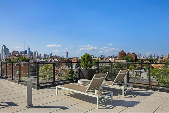 Rooftop with lounge chairs and city skyline view