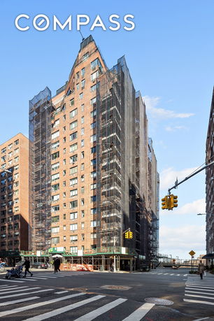 Front view of a multi-story brick apartment building under construction with scaffolding.