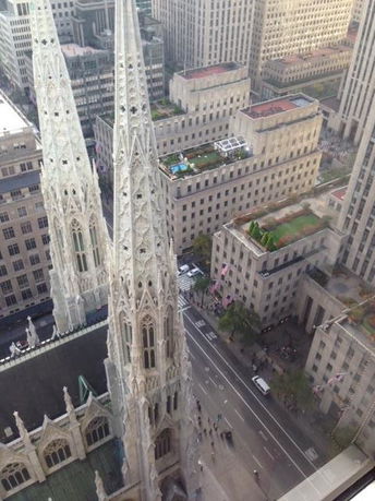 Panoramic view of city street and tall buildings as seen from a high vantage point.