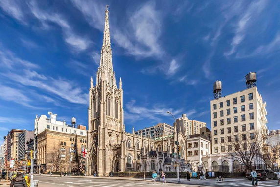 Front view of a large Gothic-style cathedral with a tall spire.