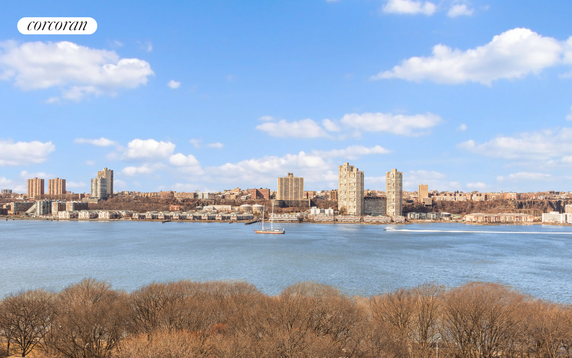Panoramic view of a skyline across a body of water with tall buildings in the distance.