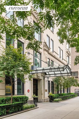 Front view of a multi-story building with an ornate entrance canopy and large windows.