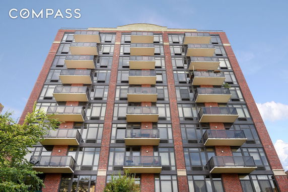 Front view of a multi-story building with balconies and large windows.