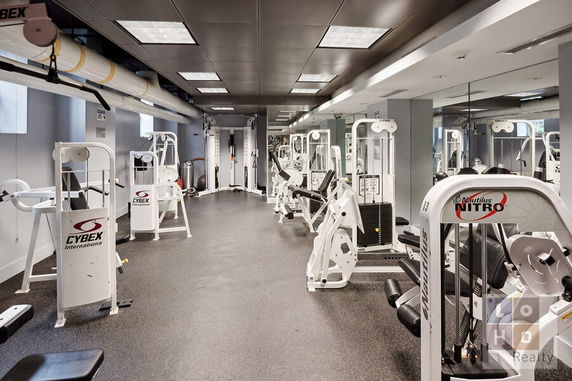 Image of an indoor gym area with various exercise machines.