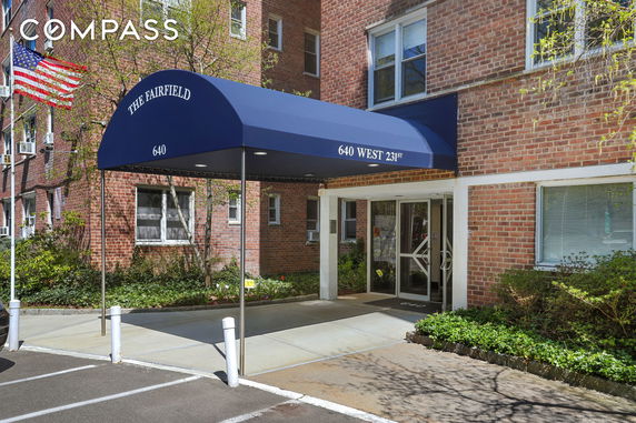 Front view of a brick building entrance with a blue awning.