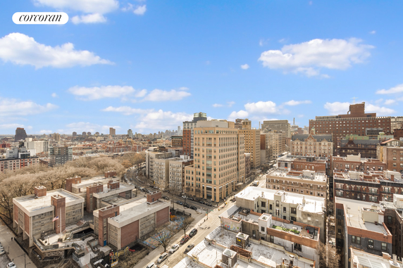 Panoramic view of a cityscape with various buildings against a blue sky.