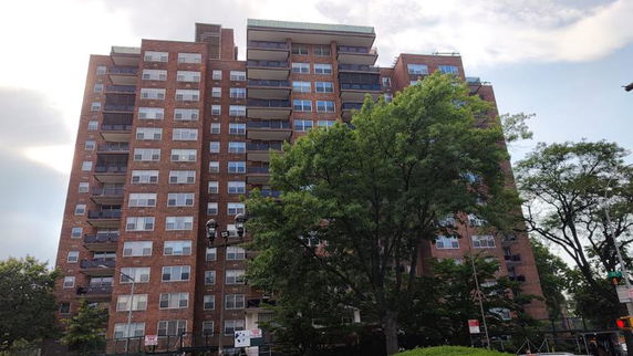 Front view of a multi-story apartment building with balconies.