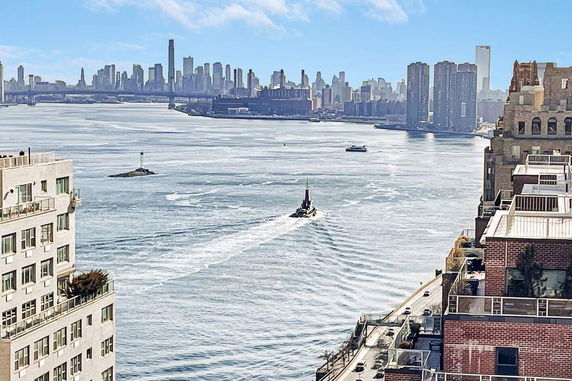 Panoramic view of a river with city skyline in the background.