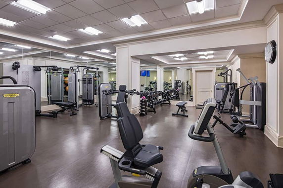 Indoor gym area with various exercise machines and equipment.