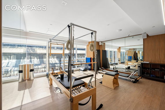 Interior view of a fitness room equipped with pilates machines and mirrors.