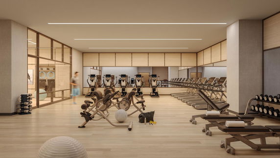 Interior view of a gym with exercise equipment and large mirrors.