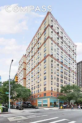 Front view of a multi-story apartment building on a street corner.