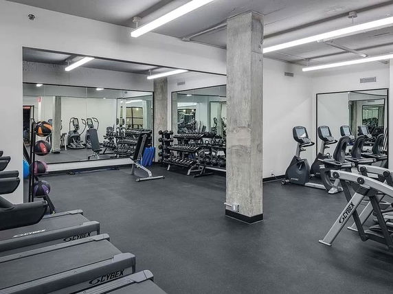 Interior view of a gym with exercise equipment and weights.
