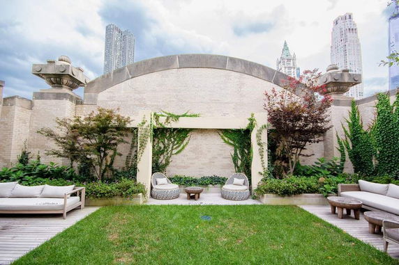 Rooftop garden area with seating and decorative plants.