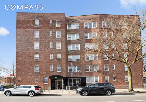 Front view of a brick residential building with multiple windows and an entrance.