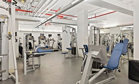 Indoor gym area with various exercise machines and gym equipment.