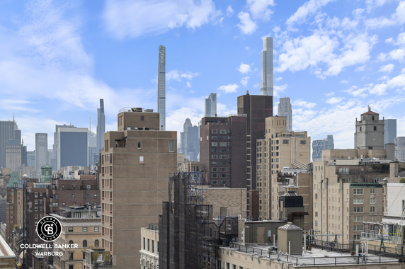 Panoramic view of a city skyline with tall buildings and a clear blue sky.